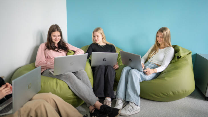 Neljä opiskelijaa tekee tehtäviään omilla tietokoneillaan.